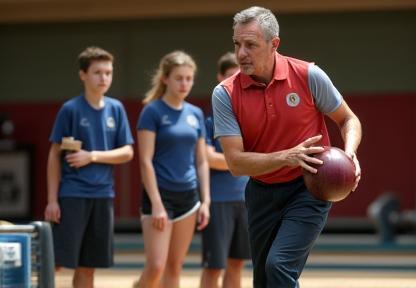 A coach demonstrating a complex bowling variation technique to a group of attentive players.